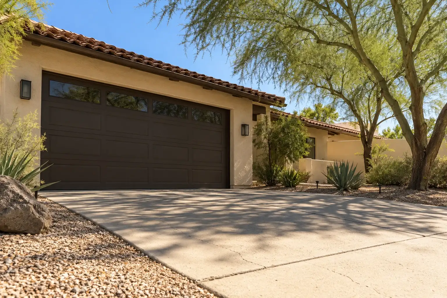 Ranch home with a dark bronze garage door seen low from the driveway